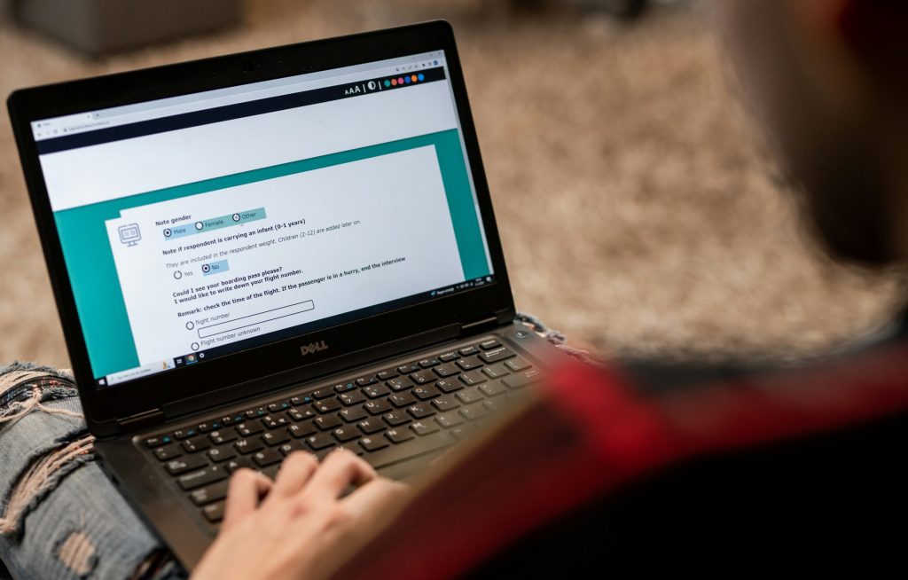 Bild mit Person, die an einem Laptop eine Online-Umfrage bearbeitet